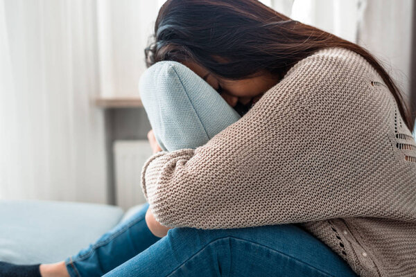 Несчастная одинокая депрессивная азиатка на диване дома
