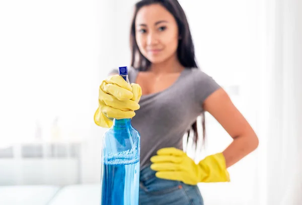 Jovem menina asiática com luvas e spray de limpeza casa — Fotografia de Stock