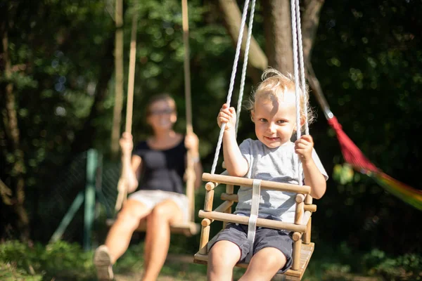 Szczęśliwe Małe Dziecko Jego Matka Huśtawkach Zewnątrz Podwórku — Zdjęcie stockowe