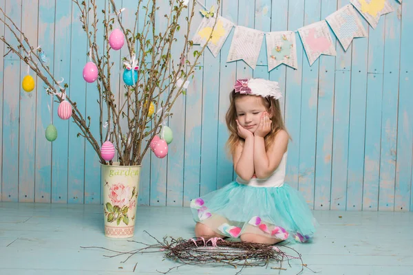 Pequeña hermana hermosa y encantadora chica junto con el conejo sentado en el suelo o silla en ropa azul brillante Pascua, huevos, humor festivo, emoción y sonrisa fiesta sorpresa celebración —  Fotos de Stock