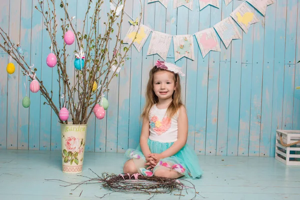 Pequeña hermana hermosa y encantadora chica junto con el conejo sentado en el suelo o silla en ropa azul brillante Pascua, huevos, humor festivo, emoción y sonrisa fiesta sorpresa celebración —  Fotos de Stock