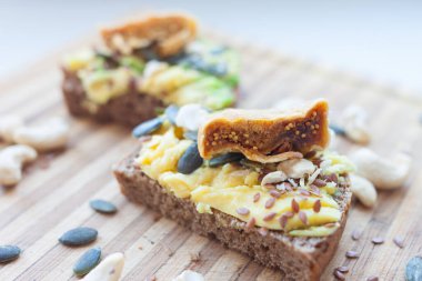 Tam tahıllı vejetaryen tostu, avokado, kaju, keten, kabak tohumu ve incir.