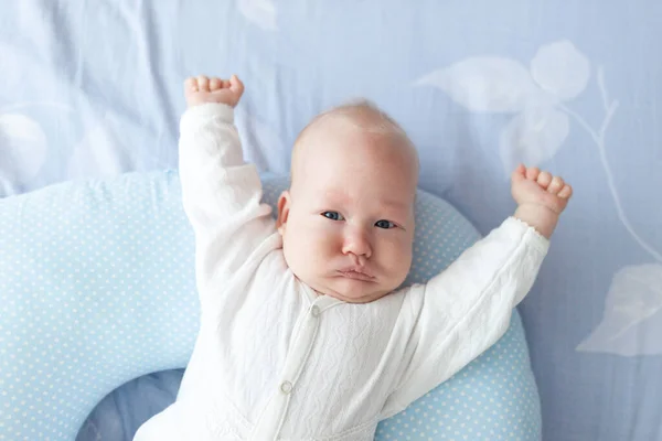 Aylık Bir Bebek Gün Işığında Ellerini Kaldırarak Bir Yastığın Üzerinde — Stok fotoğraf