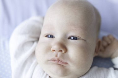 Beyaz tulumlu, beyaz dantelli, yakın plan bir bebek.