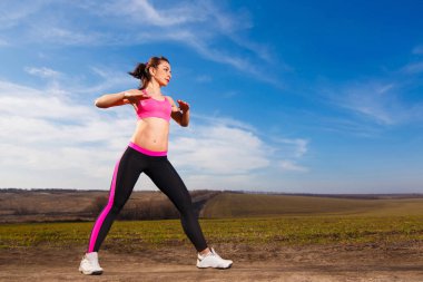 genç kadın mavi gökyüzü arka plan üzerinde yapıyor 