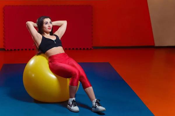 Mulher muito sorridente treinando músculos abdominais em b amarelo grande — Fotografia de Stock