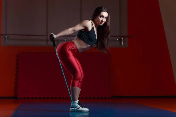 Jovem atraente mulher fitness muscular fazendo exercício com stra — Fotografia de Stock