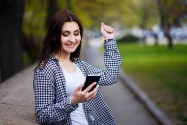 Akıllı telefon s içinde tutan genç oldukça stil sahibi exulting kadın