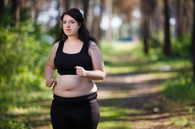 Kilolu kadın parkta koşu. 