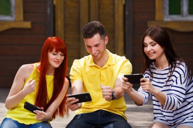 Adam açık havada, mobil video oyun oynarken gülüyor gençlik grubu 