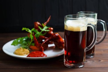 Lezzetli sıcak kaşarlı ızgara tavuk ile koyu bira iki kupalar 