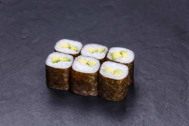 Avokado, üzerinde siyah taş kayrak hizmet ile suşi rulo. Japonca 