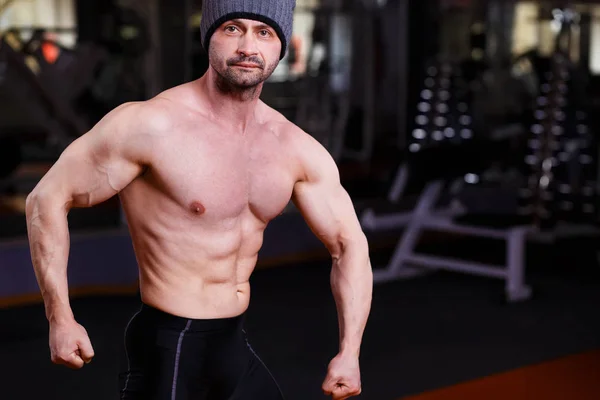 Forte homem adulto saudável rasgado com grandes músculos posando no ginásio — Fotografia de Stock