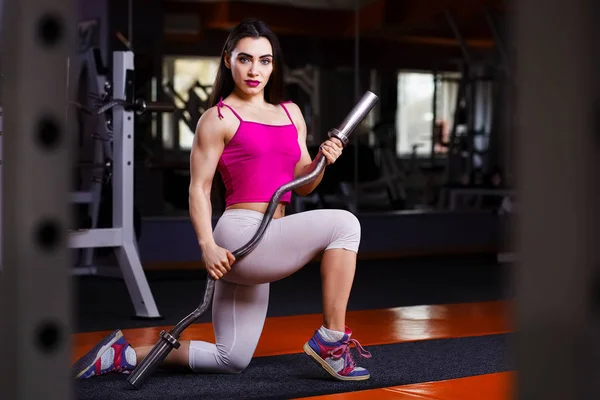 Joven atractivo muscular sexy fitness mujer posando con barra —  Fotos de Stock