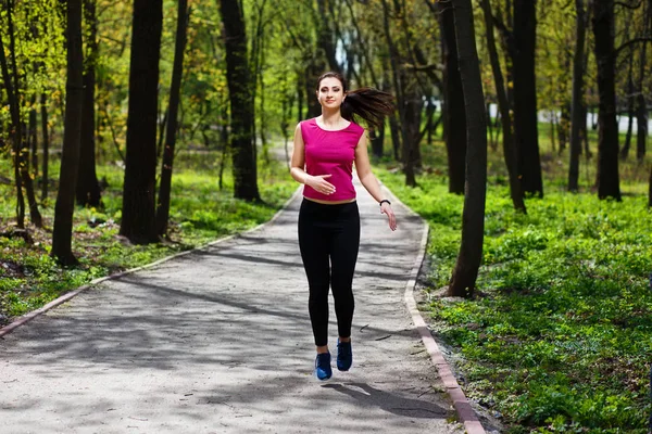 Jovem mulher bonita em forma correndo no parque . — Fotografia de Stock