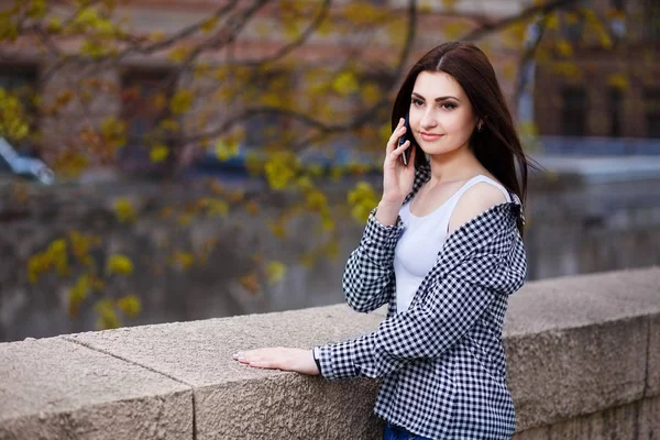 Jeune femme assez élégant parler sur le téléphone intelligent dans la ville pa — Photo