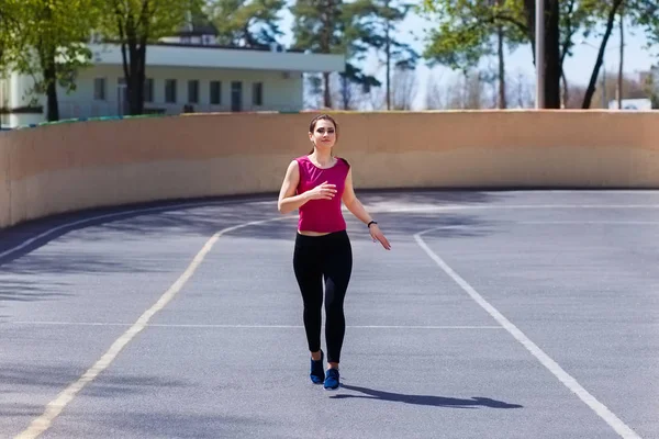 Young passen vrij vrouw joggen op de athletic field — Stockfoto