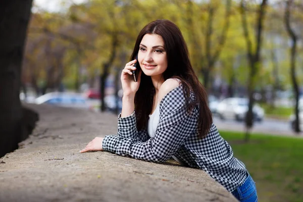 Jeune femme assez élégant parler sur le téléphone intelligent dans la ville pa — Photo