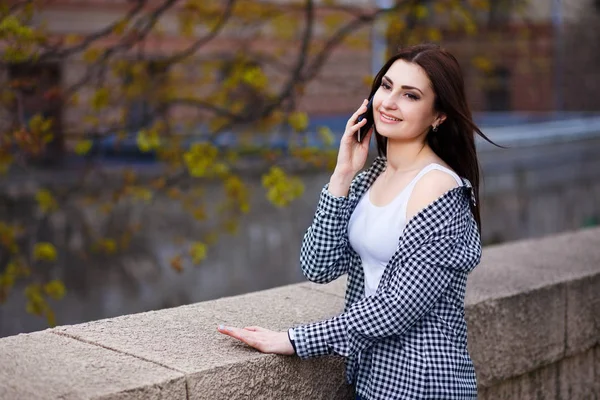 Jeune femme assez élégant parler sur le téléphone intelligent dans la ville pa — Photo