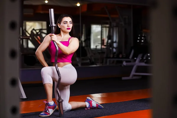 Joven atractivo muscular sexy fitness mujer posando con barra —  Fotos de Stock