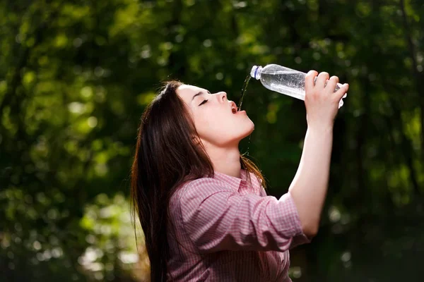 Feliz hermosa joven sedienta mujer beber agua . — Foto de Stock