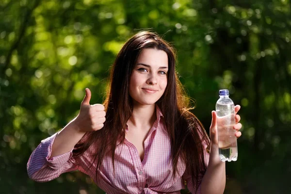 Happy beautiful young smiling woman holding a bottle of clean wa — Stock Photo, Image