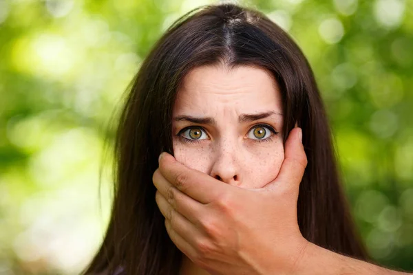 Closeup image of a mans hand covering a scared womans mouth — Stock Photo, Image