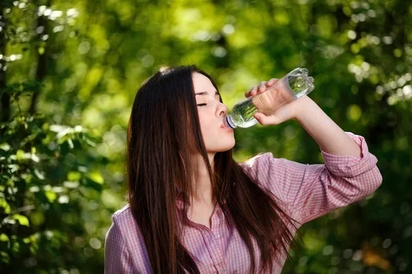 Glad vacker ung törstig kvinna dricksvatten från Oh — Stockfoto