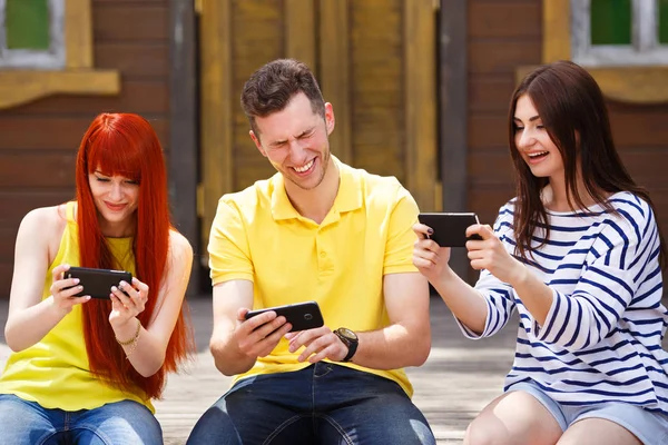 Grupa trzech znajomych gry mobilne wideo gry na zewnątrz, dziewczyny wi — Zdjęcie stockowe