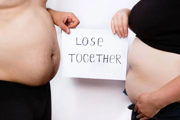 Close-up portrait of man and woman obese bellies and hands holdi — Stock Photo, Image