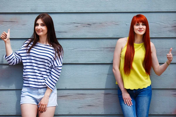 Deux belles jeunes femmes en vêtements décontractés lumineux posant en plein air — Photo