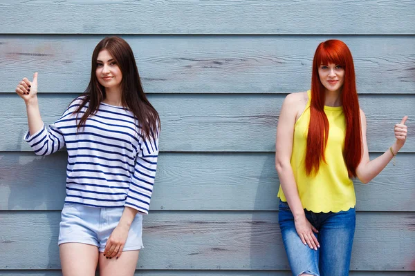 Duas belas mulheres jovens em roupas casuais brilhantes posando outdoo — Fotografia de Stock