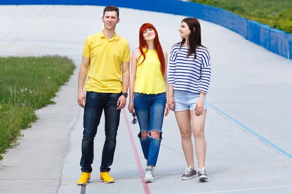 Groupe de trois jeunes amis marchant dans la ville . — Photo