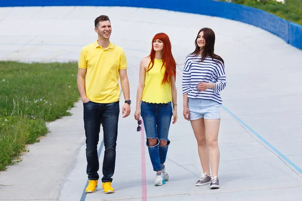 Grupo de três jovens amigos caminhando na cidade . — Fotografia de Stock