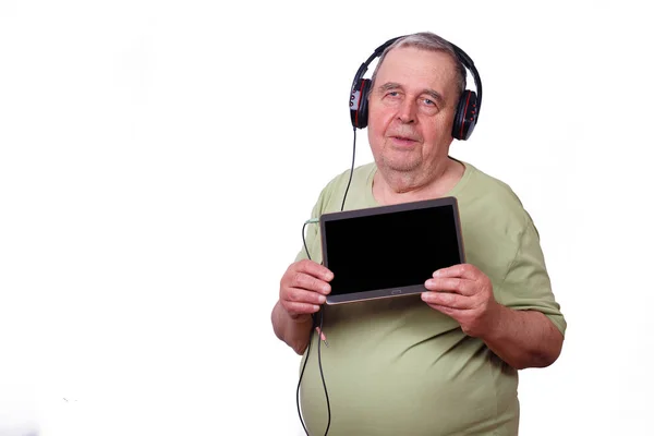 年配の男性、年金受給者、タブレットを使用してヘッドフォンで m を聞いて — ストック写真