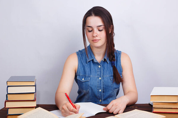 Student girl studying, reading textbook and noticing material to