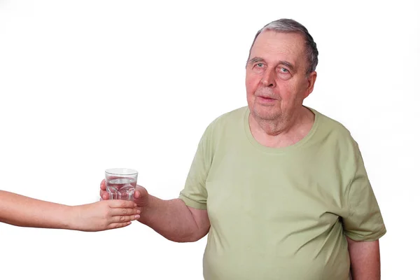 Старик с избыточным весом берет стакан воды из чьей-то руки. Он — стоковое фото