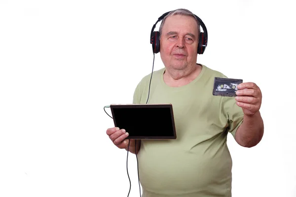 Portrait of old man listening to music in earphones using a tabl — Stock Photo, Image