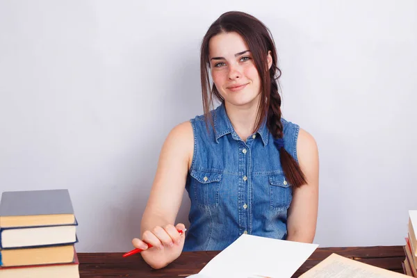 Boş pape ile masada oturan genç gülümseyen öğrenci kadın — Stok fotoğraf