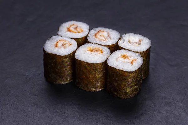 Rotoli di sushi tradizionali con anguilla affumicata serviti su ardesia nera, J — Foto Stock