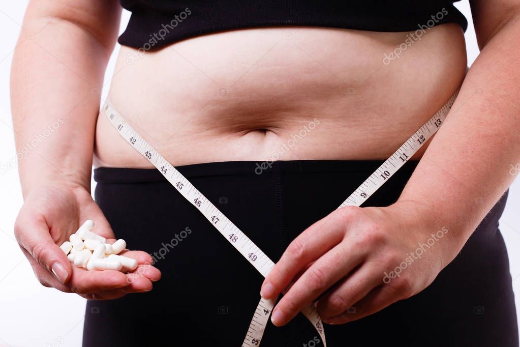 Young overweight unrecognizable woman with measuring tape around