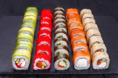 Japon suşi ayarla - çeşitli maki sushi roll üzerinde siyah taş kayrak. Japon mutfağı kavramı