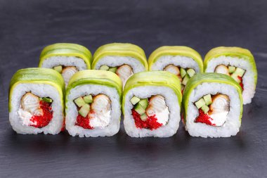 Füme yılan balığı ve avokado dilimler halinde sarılmış havyar, lezzetli suşi rulo. Restoran gıda, Japon gıda sanat