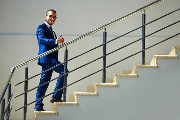 Stairs to success. Young smiling businessman climbs the stairs. Career concept — Stock Photo, Image