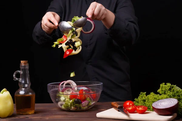 Chef cuidadosamente mezcla ensalada fresca de verano en un tazón. Proceso de cocción — Foto de Stock