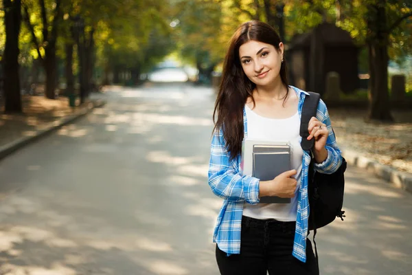 Młoda ładna kobieta uśmiechający się student z plecaka i notebooki sta — Zdjęcie stockowe