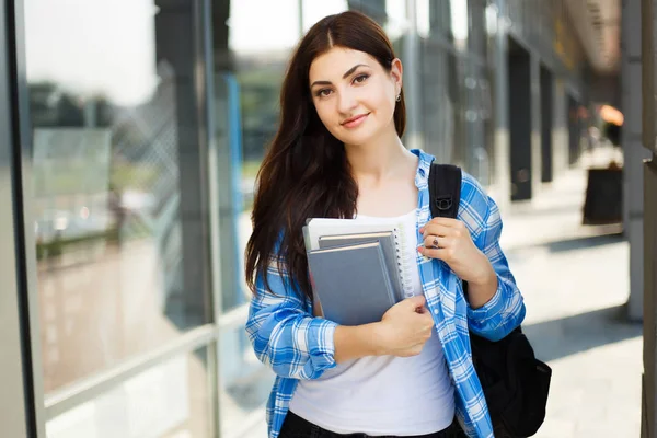 Joven linda mujer sonriente con mochila y cuadernos de pie ne —  Fotos de Stock