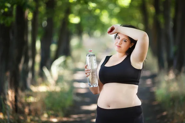 Gruba kobieta biorąc breather, wycieranie potu i drinkin z nadwagą — Zdjęcie stockowe