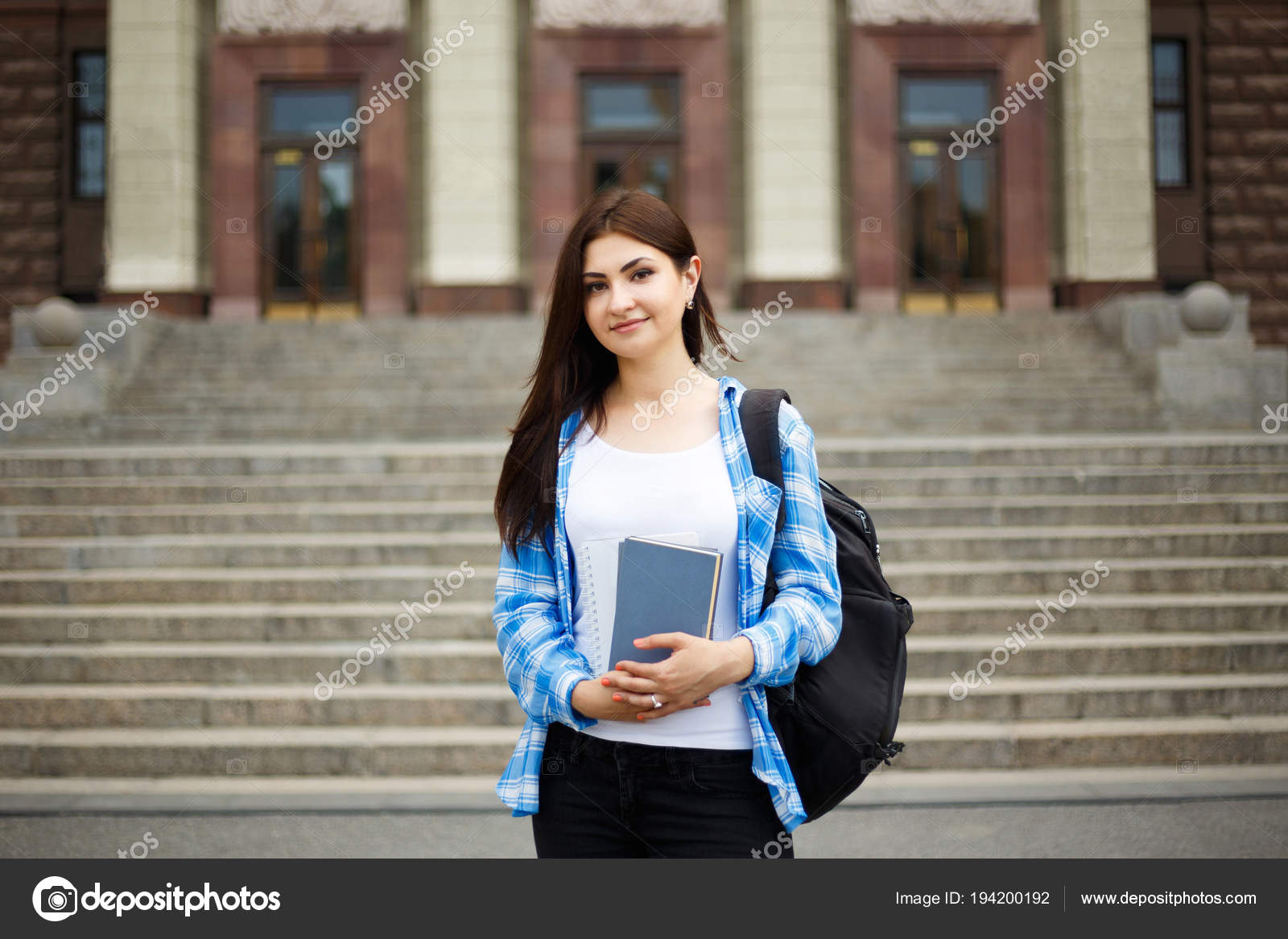 Student girl with books and backpack standing near university bu — Stock Photo © Wadym #194200192