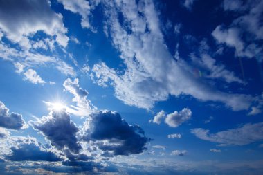 Dramatik bulutlar ve güneş ile derin mavi gökyüzü